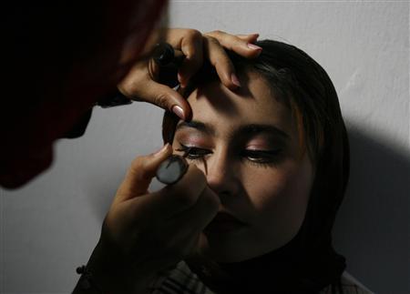 Applying eye liner to Afghan model